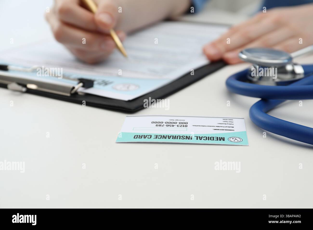 Medico con penna che compila il modulo di politica a tavola bianca, concentrarsi sulla carta di assicurazione medica Foto Stock