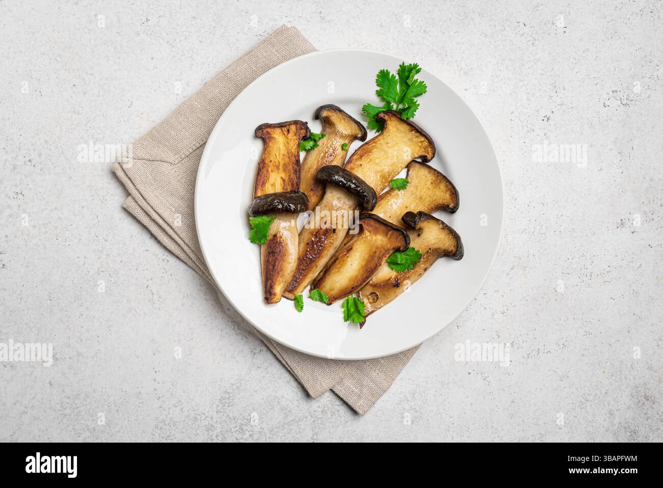 Bistecca di funghi grigliati King Oyster pronti da mangiare, vista dall'alto. Cibo vegetariano vegano sano, fonte di proteine vegetali, funghi Eryngii con ciliantro. Foto Stock