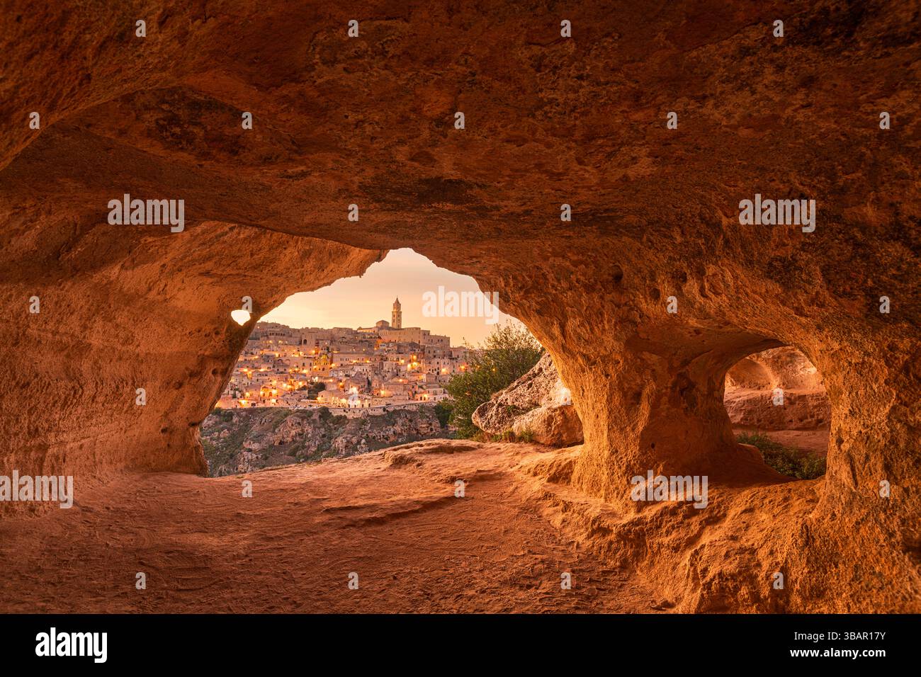 Matera, Italia come si vede dall'interno di un'antica grotta al crepuscolo. Foto Stock