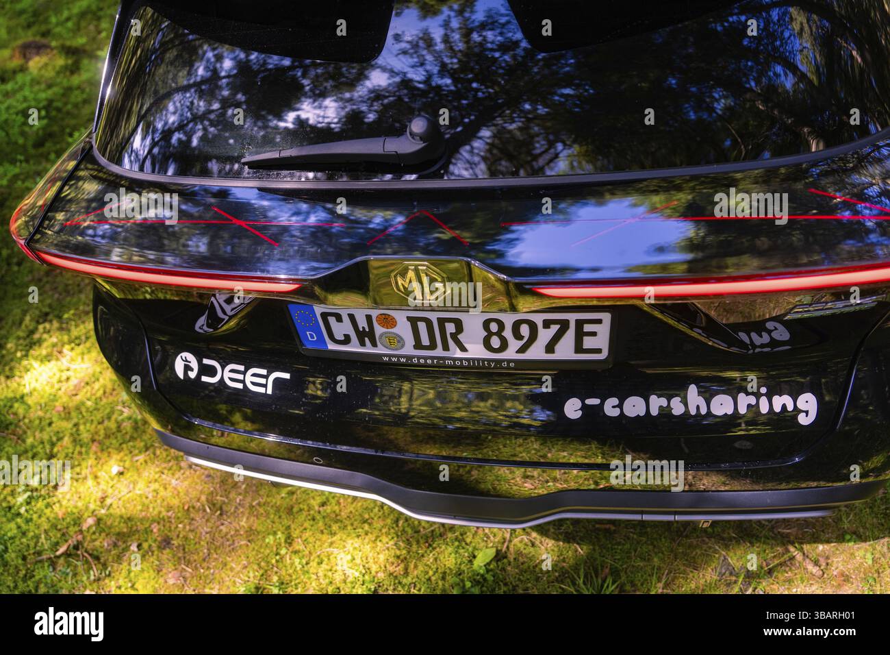 Vista posteriore di un'auto nera lucida con scritta e-carsharing nella foresta, Deer e- Carsharing, Calw, Foresta Nera, Germania, Europa Foto Stock