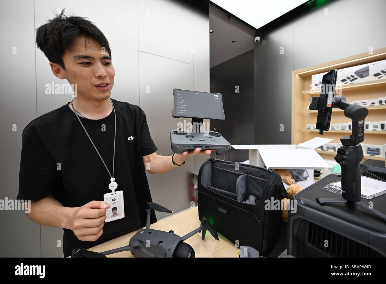 NANJING, CINA - 13 MAGGIO 2025 - Un membro dello staff di un negozio DJI presenta il nuovo telecomando pieghevole DJI RC Pro 2 con uno schermo Mini-LED da 7 pollici ad alta luminosità a Nanjing, provincia di Jiangsu, Cina, il 13 maggio 2025. Foto Stock