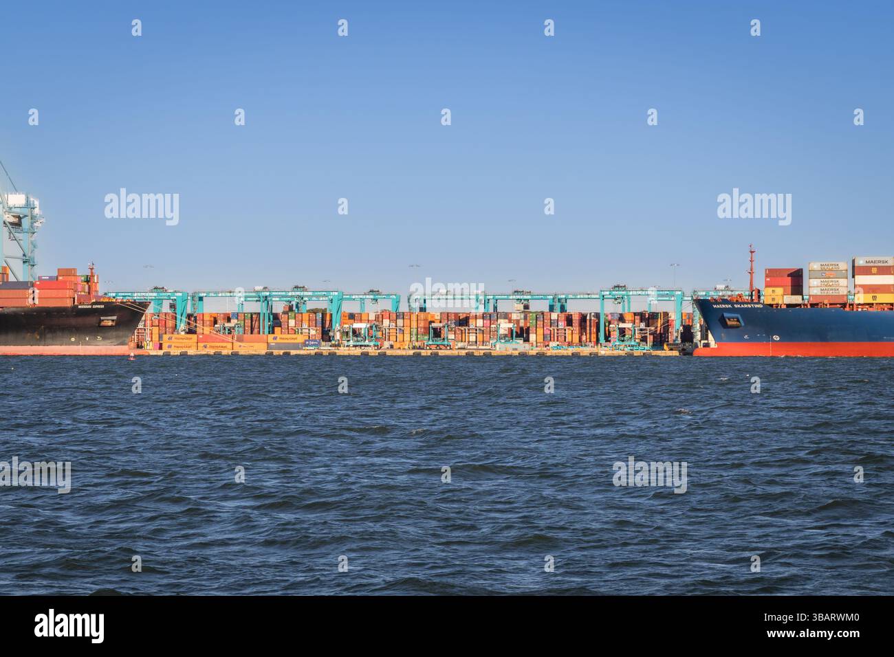 Norfolk, Virginia, Stati Uniti - 1 maggio 2025: Grandi navi cargo internazionali in porto caricate di container durante la guerra tariffaria Trump creando forniture c Foto Stock