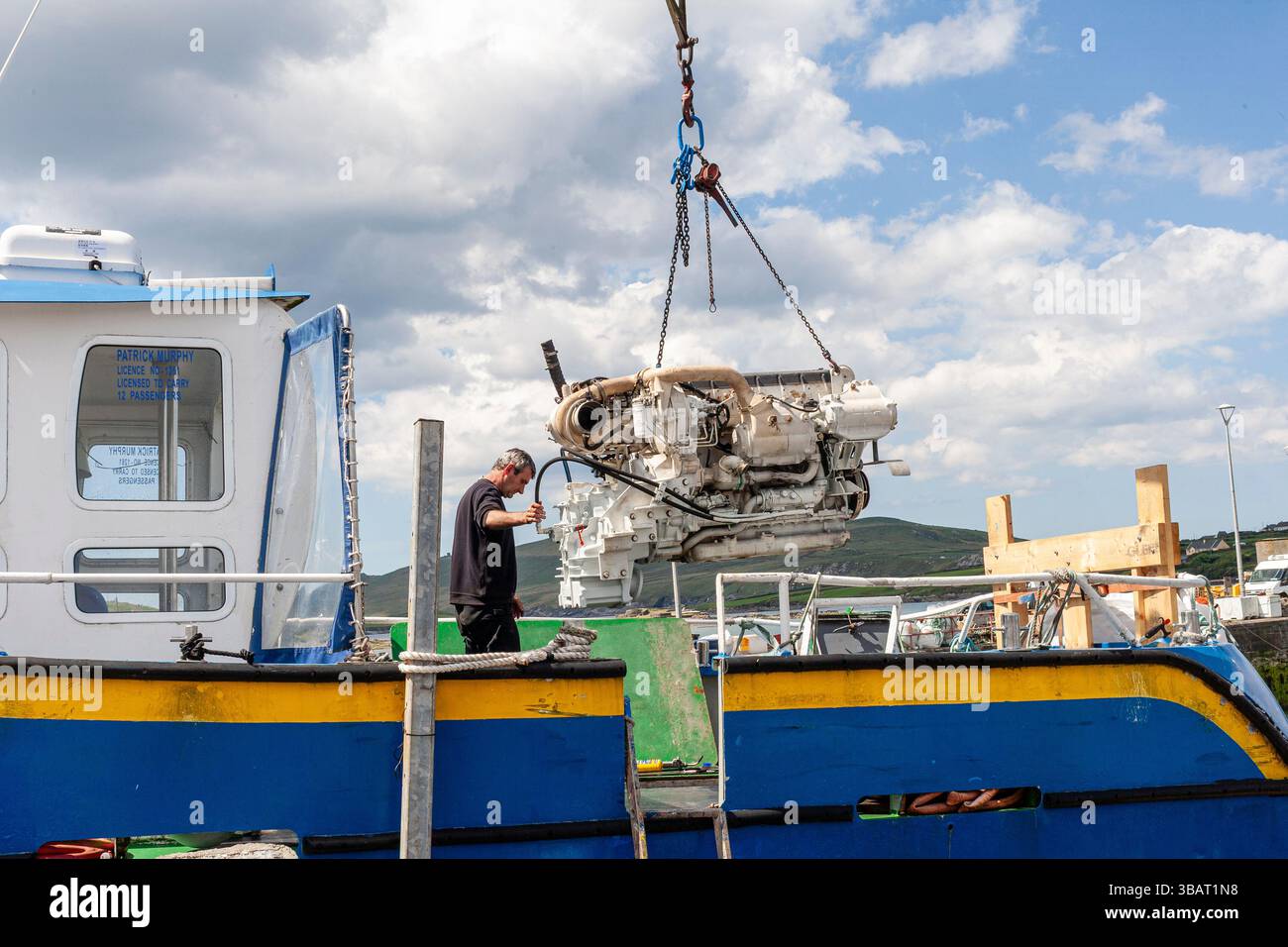 Nuovo motore per barche installato su imbarcazioni turistiche tramite gru, Portmagee, Contea di Kerry, Irlanda Foto Stock