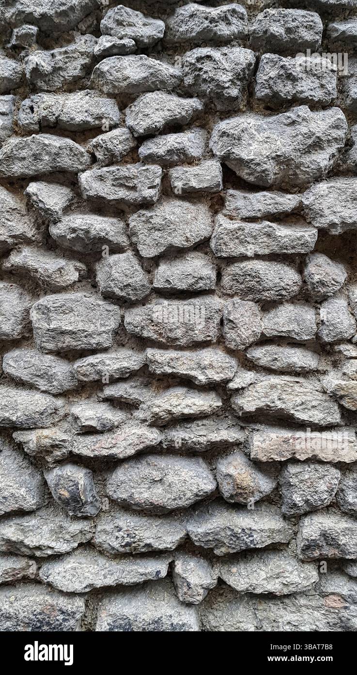 Parete ruvida rivestita con grandi ciottoli e texture ravvicinata Foto Stock