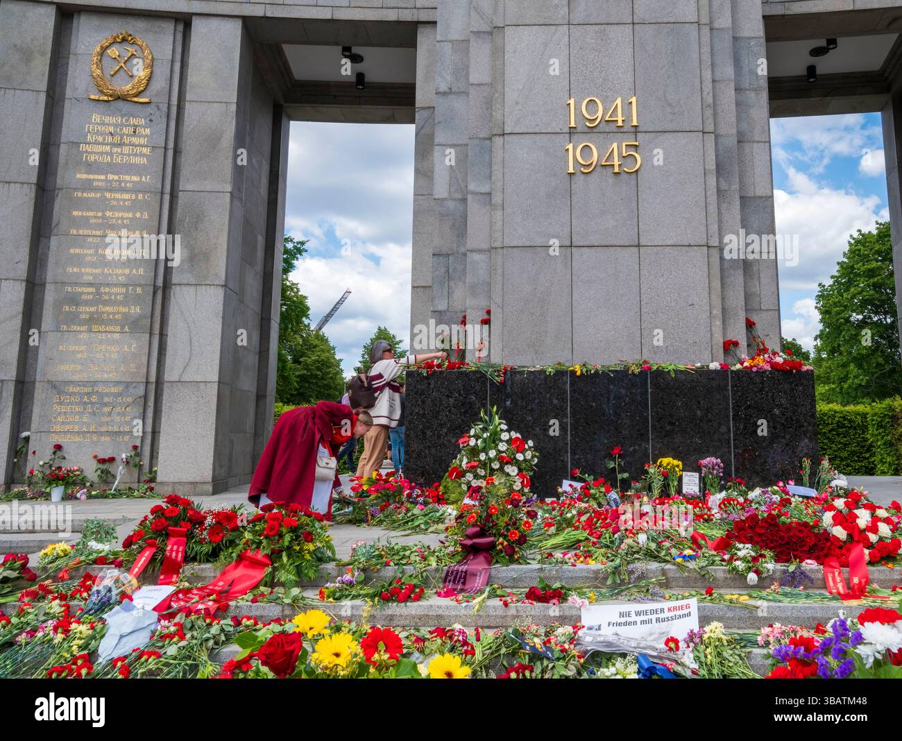 Ecco una didascalia che descrive l'immagine: Le persone stanno posando fiori al Memoriale di guerra sovietico di Berlino, Germania. Il memoriale commemora i sovietici Foto Stock