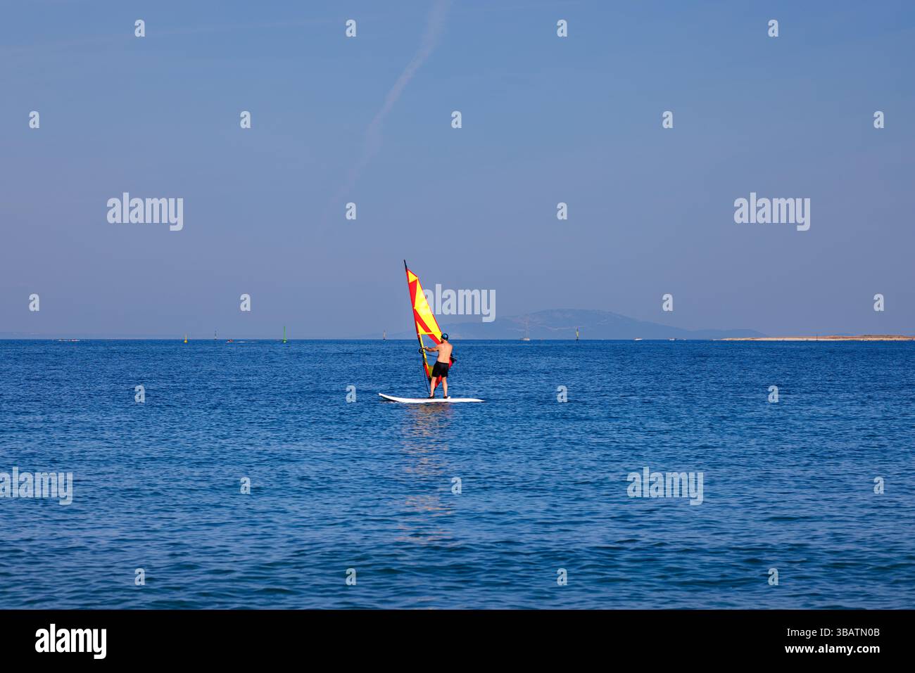 Premantura, Croazia - 22 agosto 2024: Uomo che frequenta una scuola di windsurf a Capo Kamenjak, vicino a Premantura in Istria, Croazia. La scena cattura un Foto Stock