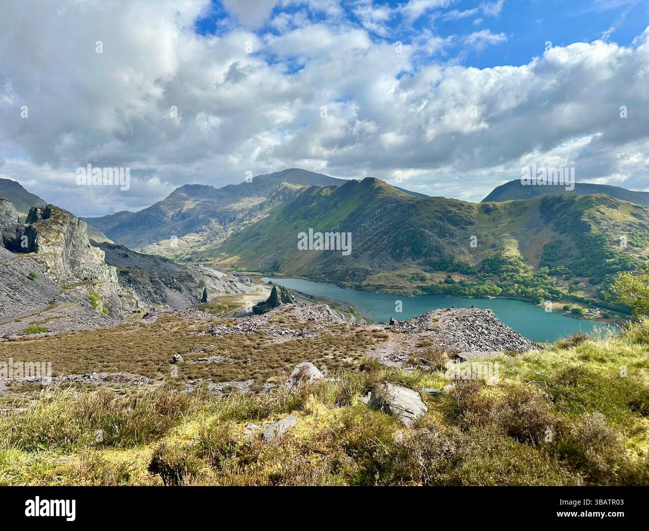 Vista panoramica sopraelevata dalla cava Dinorwic che si affaccia su Llyn Paris con il suggestivo paesaggio montano di Snowdonia sullo sfondo. Giorno luminoso. Foto Stock