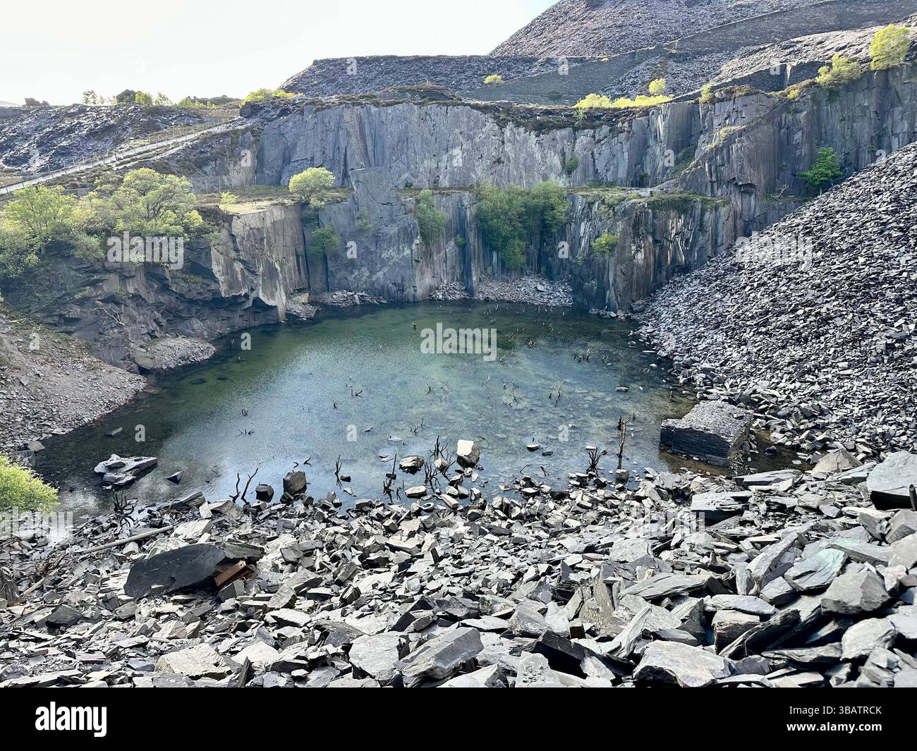 Guardando in basso sul Sinc Harriet (Dali's Hole), una suggestiva laguna annidata nella cava Dinorwic, Llanberis, nel Galles del Nord, con suggestivi dintorni di ardesia. - Immagine stock catturata con smartphone