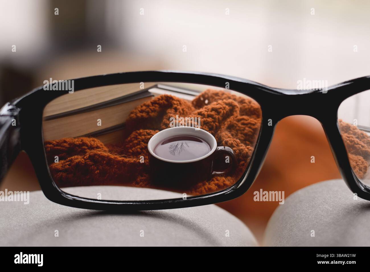Guardando attraverso le lenti correttive degli occhiali alla tazza di tè avvolta da una sciarpa calda, concetto di correzione della visione Foto Stock
