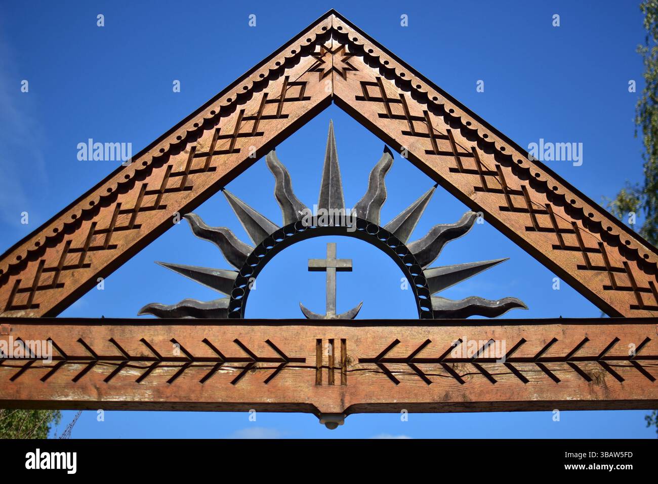 Porta tradizionale lituana in legno con sculture popolari, sole, croce e simboli della luna. Una miscela di motivi baltici e cristiani, che mostrano l'herit culturale Foto Stock