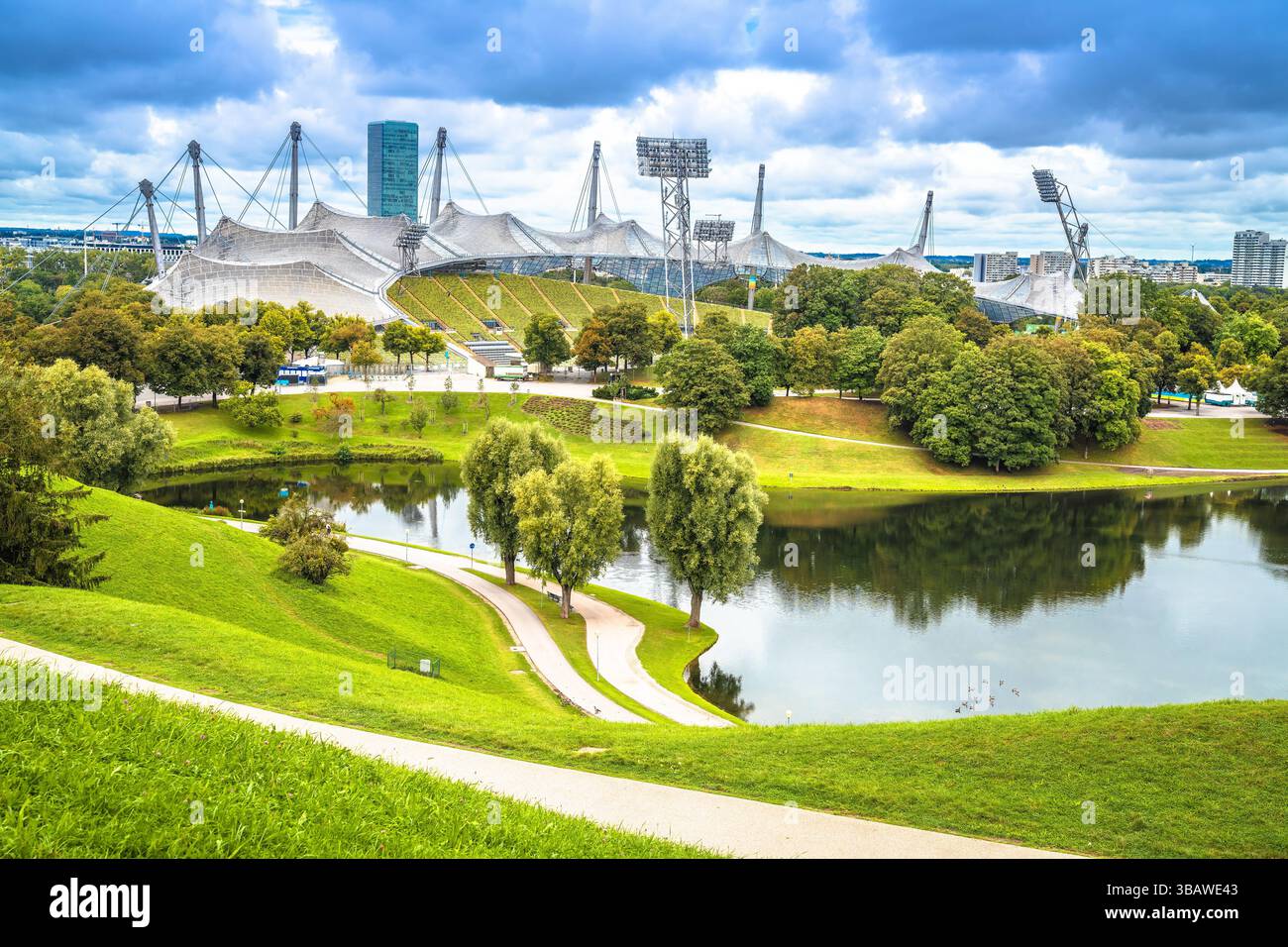Stadio Olympiapark di Monaco e vista sul lago Olympiasee, anatre davanti, capitale della Baviera, Germania Foto Stock
