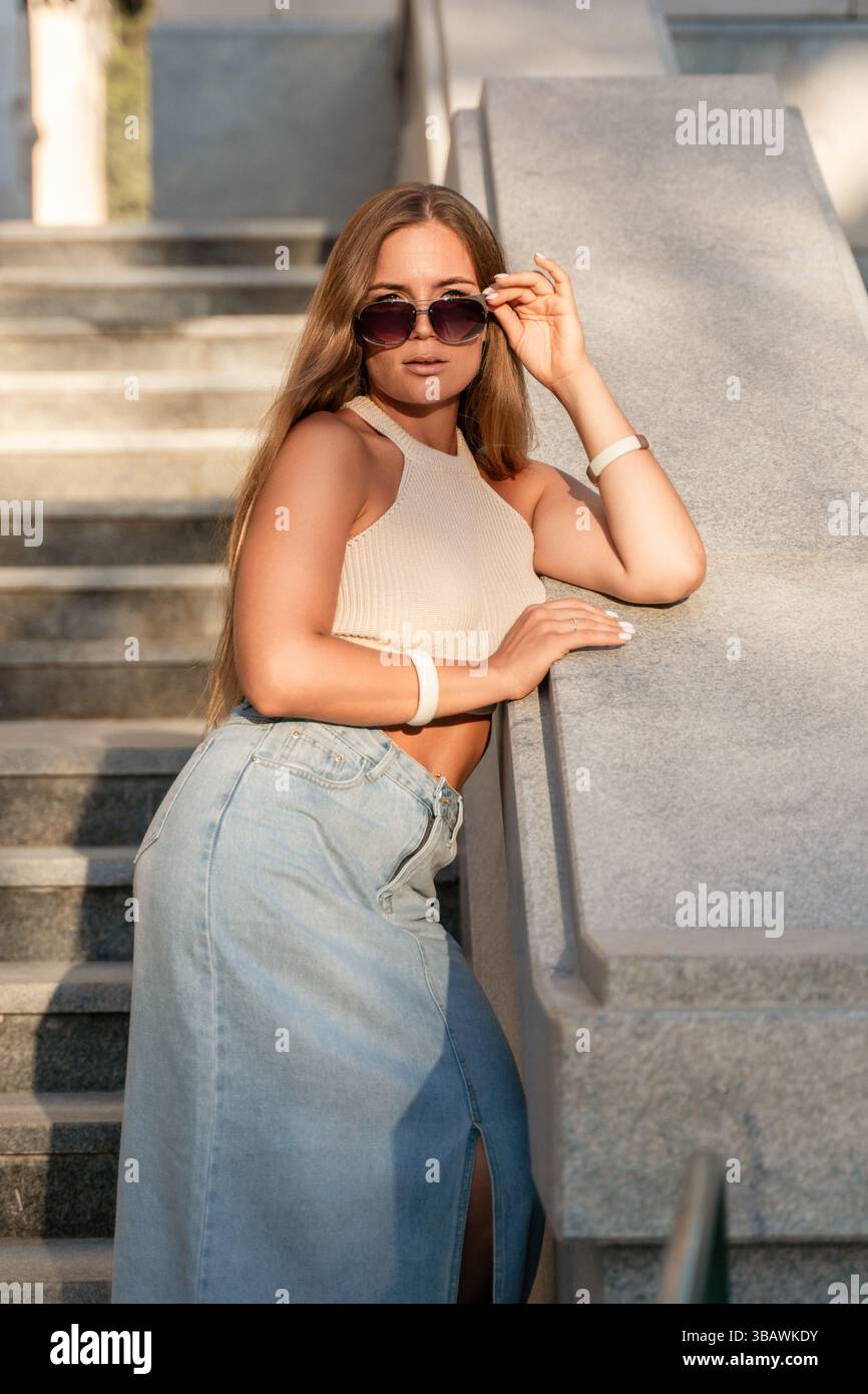 Occhiali da sole donna eleganti scale in posa luce solare all'aperto Foto Stock