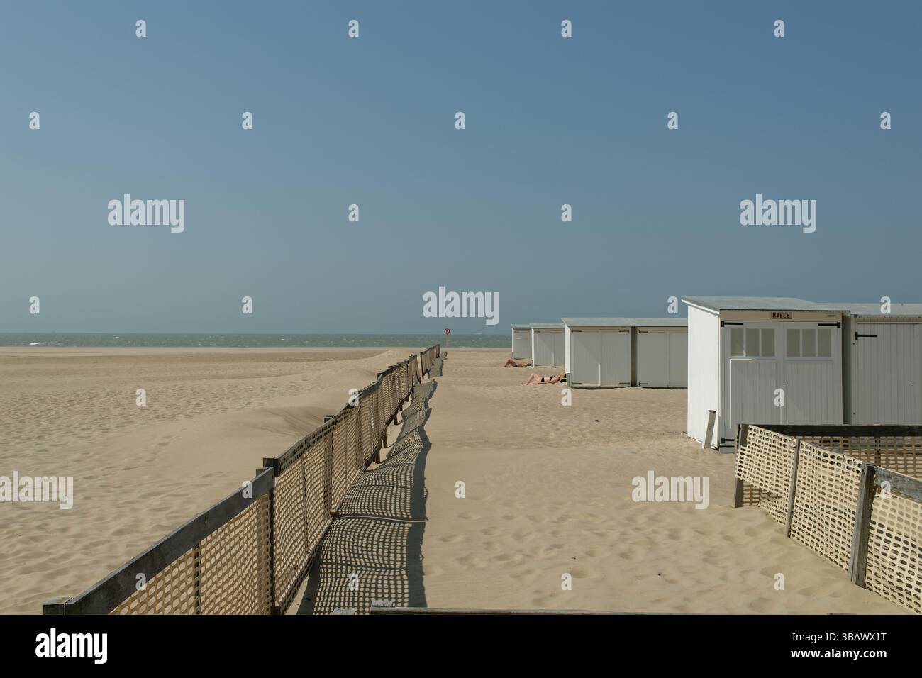 01.01.2020, Belgio, Fiandre occidentali, De Haan - Spiaggia del Mare del Nord. Inizio stagione. Le cabine sulla spiaggia sono allineate dietro una recinzione a vento. 00U230606D041CAROEX.J Foto Stock