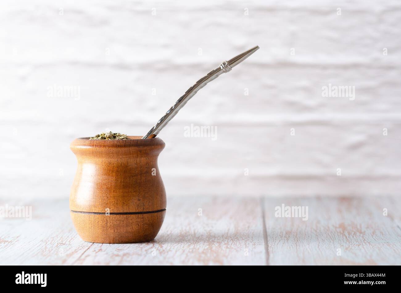 Un compagno di legno con bombilla e Yerba mate su sfondo chiaro. Foto Stock