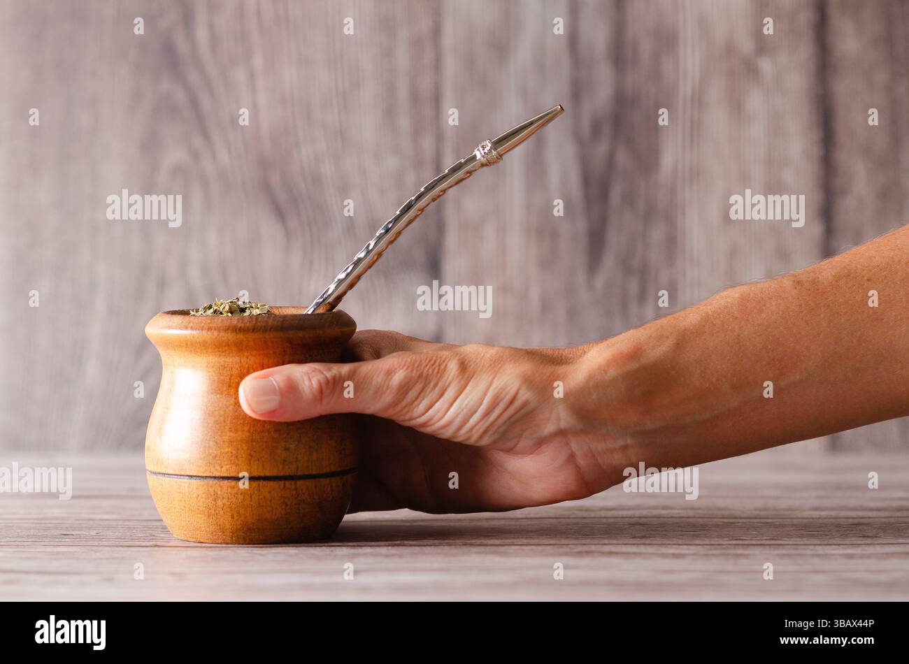 Una donna che afferra un compagno di legno su fondo di legno. Foto Stock