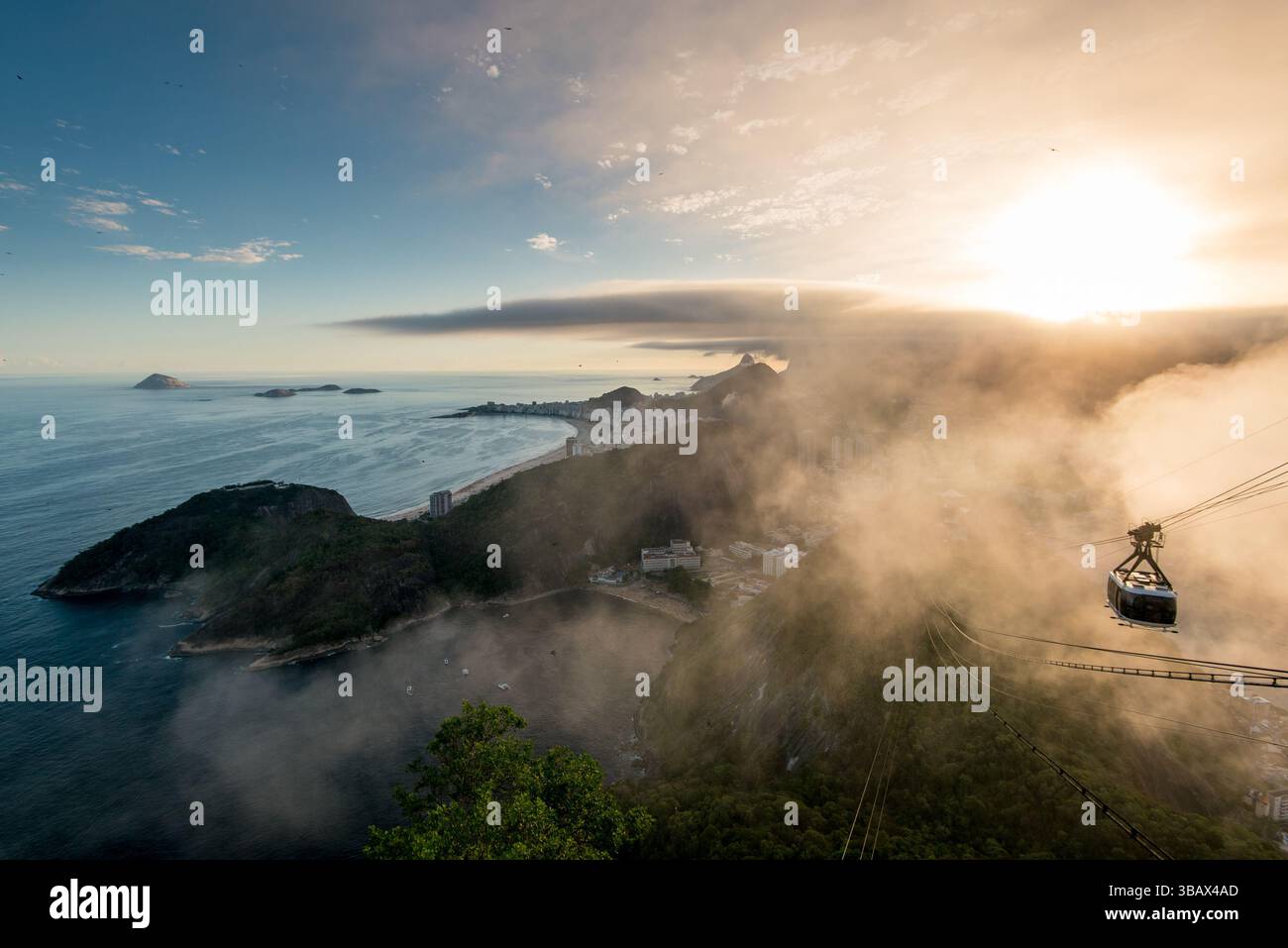 Famosa vista della costa di Rio de Janeiro dal Pan di zucchero sotto le nuvole al tramonto e in avvicinamento con la funivia Foto Stock