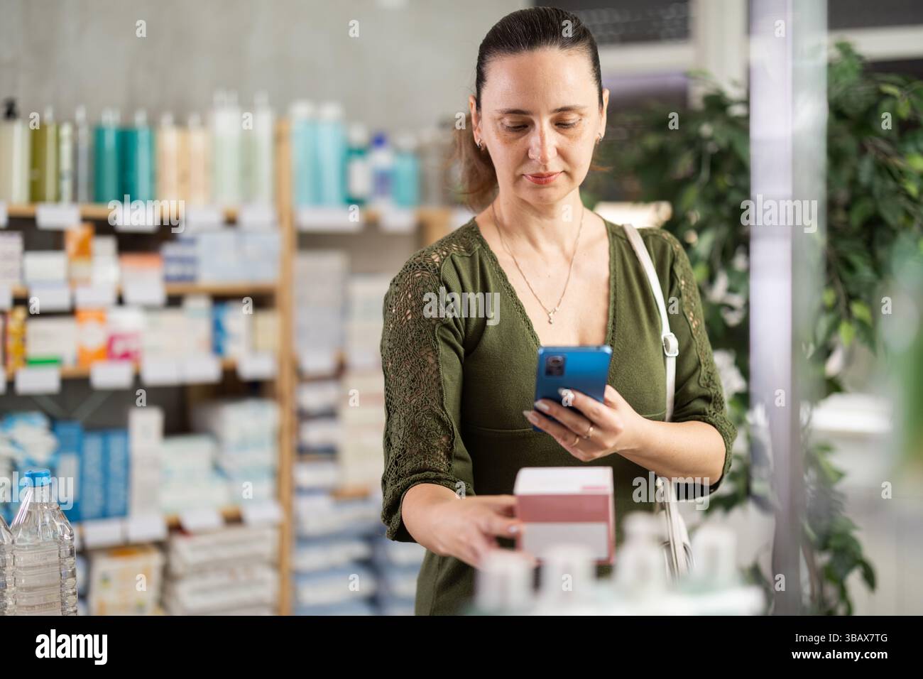 Donna di mezza età che esegue la scansione della confezione di pillole Foto Stock