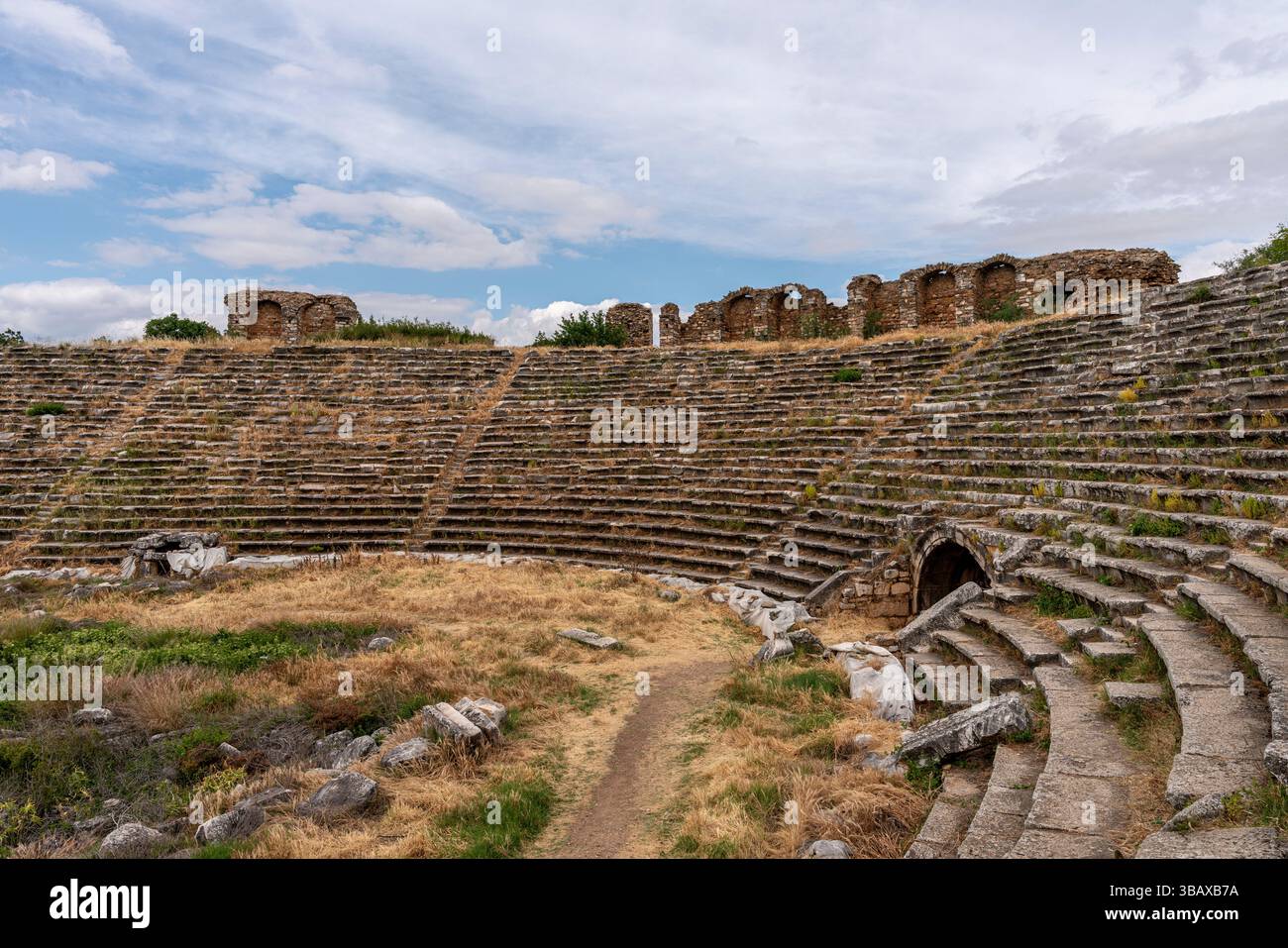 Antico stadio di Afrodisia, con file di posti a sedere ad arco e resti di una grande arena atletica, circondato da paesaggi aspri. Foto Stock