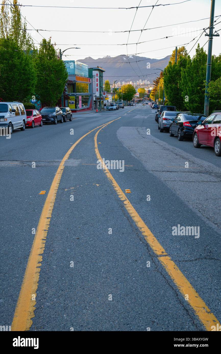 Commercial Drive a Vancouver, British Columbia, guardando verso le North Shore Mountains. Foto Stock