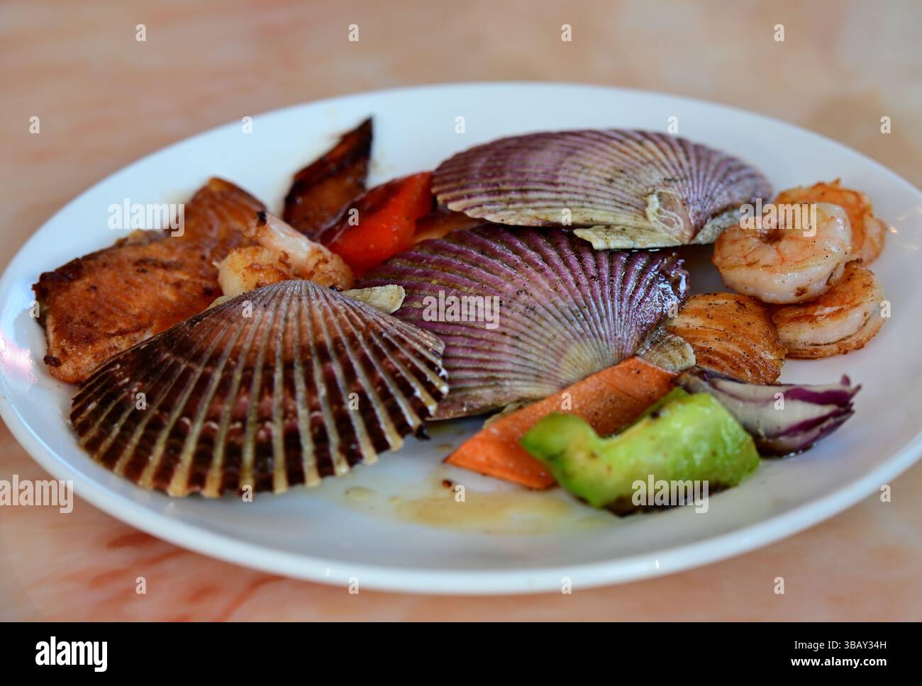 piatto con capesante grigliate, salmone e verdure Foto Stock