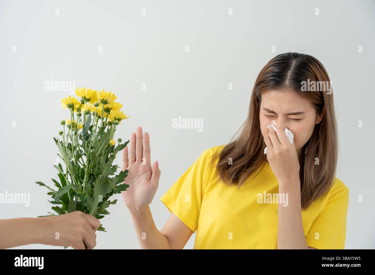 Allergie al polline, giovane donna asiatica starnuti in un fazzoletto o soffiare in una salvietta, allergica ai fiori primaverili selvatici o ai fiori in primavera. allerg Foto Stock