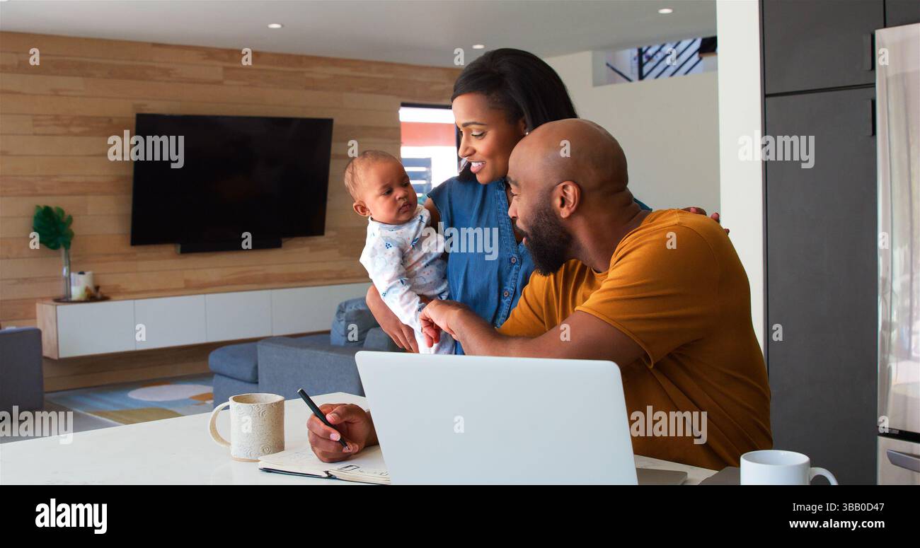 Famiglia afroamericana con figlia del bambino che usa il laptop per controllare Finanze a casa Foto Stock