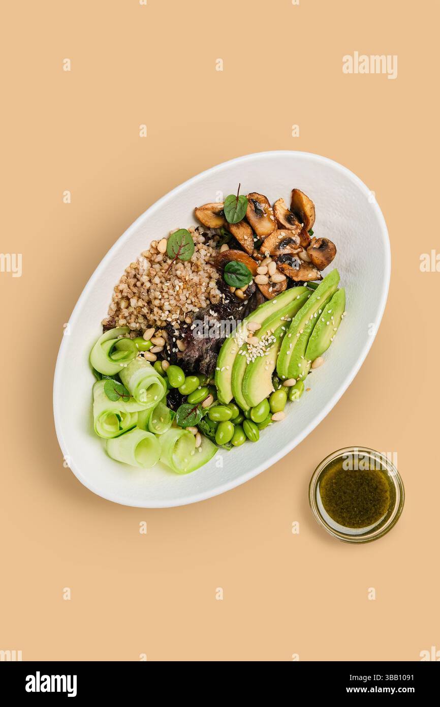 Un'insalata vivace e colorata con una varietà di cereali, verdure fresche e un condimento deliziosamente saporito Foto Stock