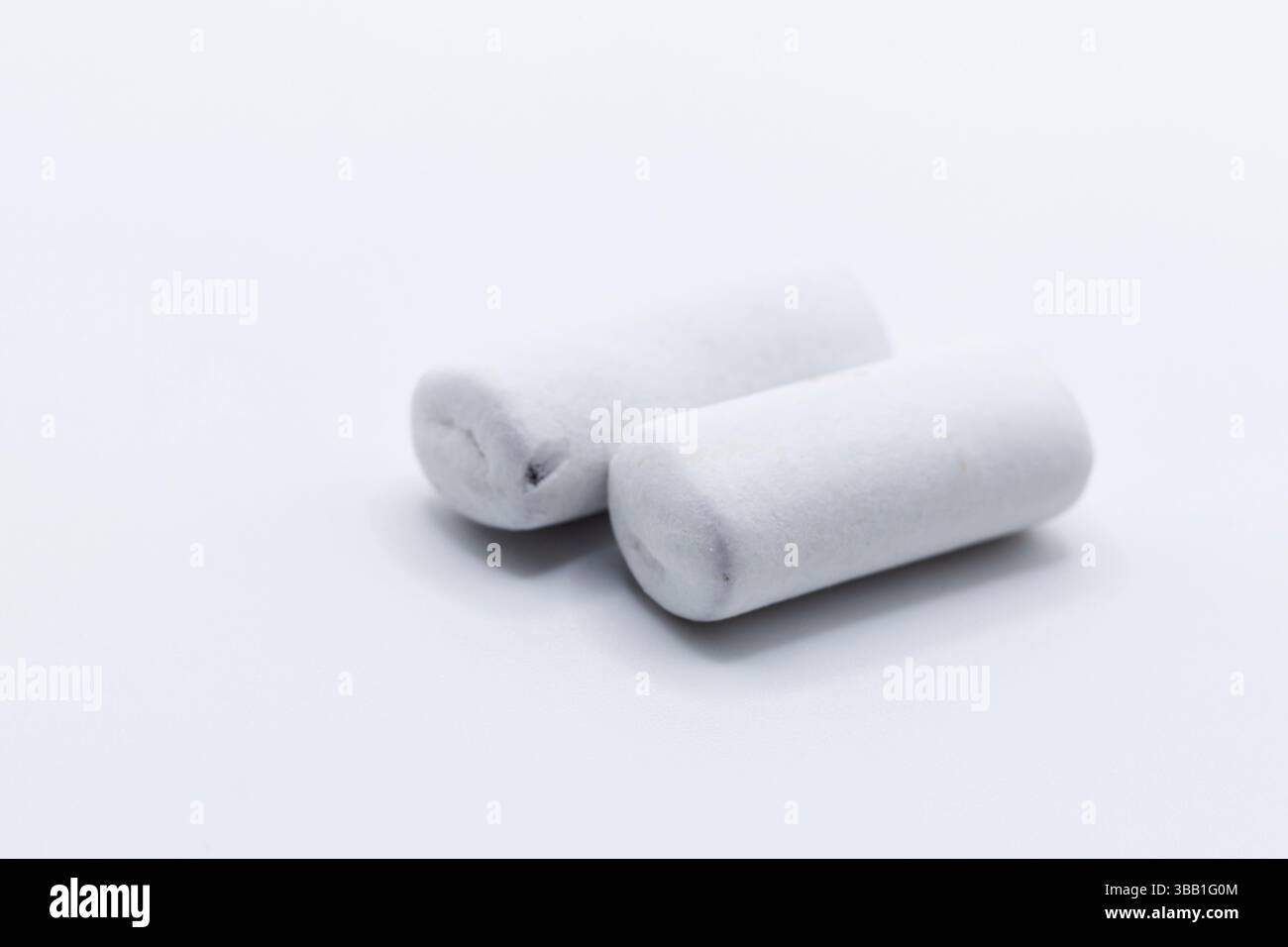 Due pezzi cilindrici bianchi di liquirizia, che mostrano la variante più leggera della liquirizia nordica tradizionale. Queste caramelle bianche con gesso presentano la stessa classe Foto Stock