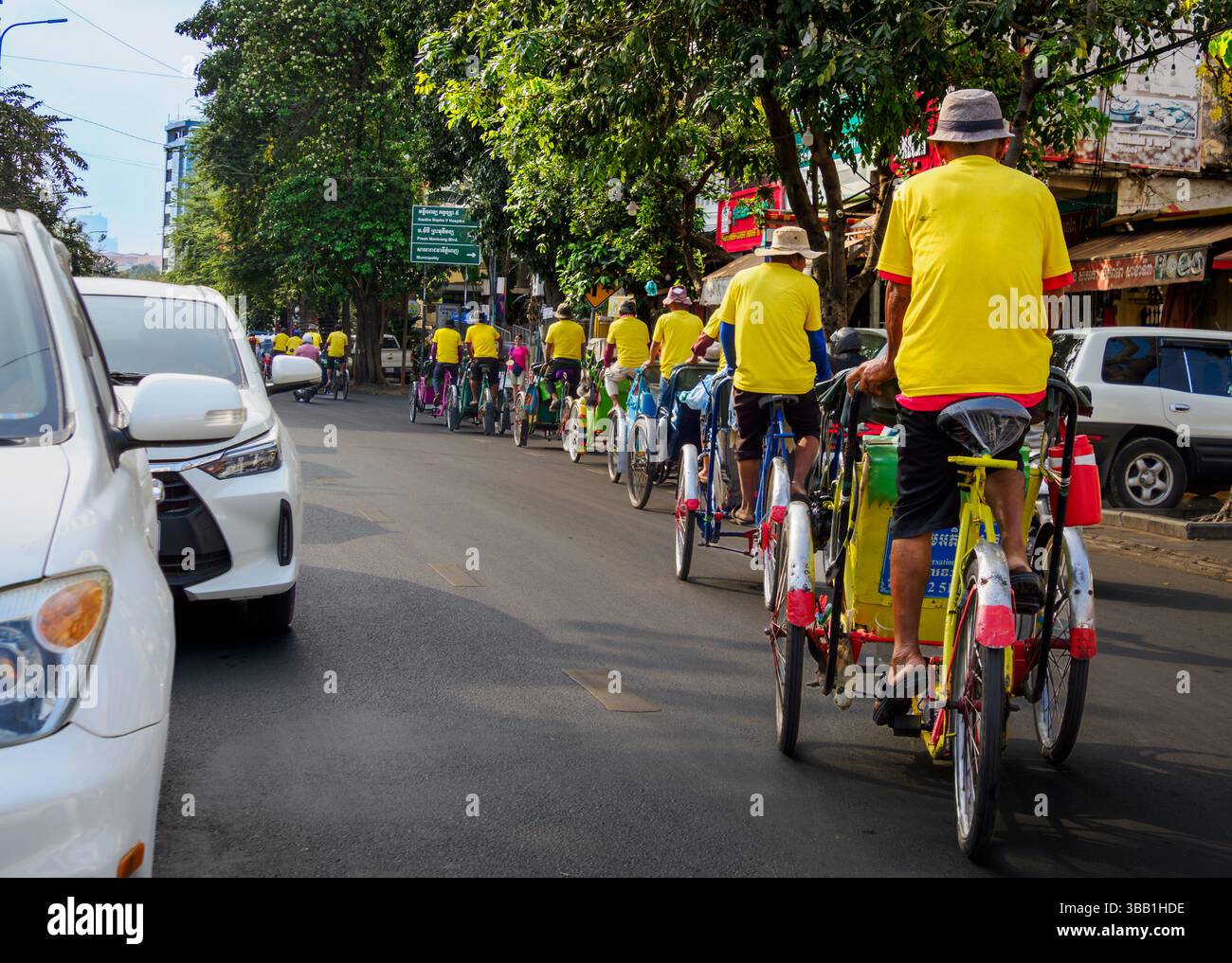 Un gruppo di turisti sperimenta un giro in bicicletta a Phnom Penh, Cambogia Foto Stock