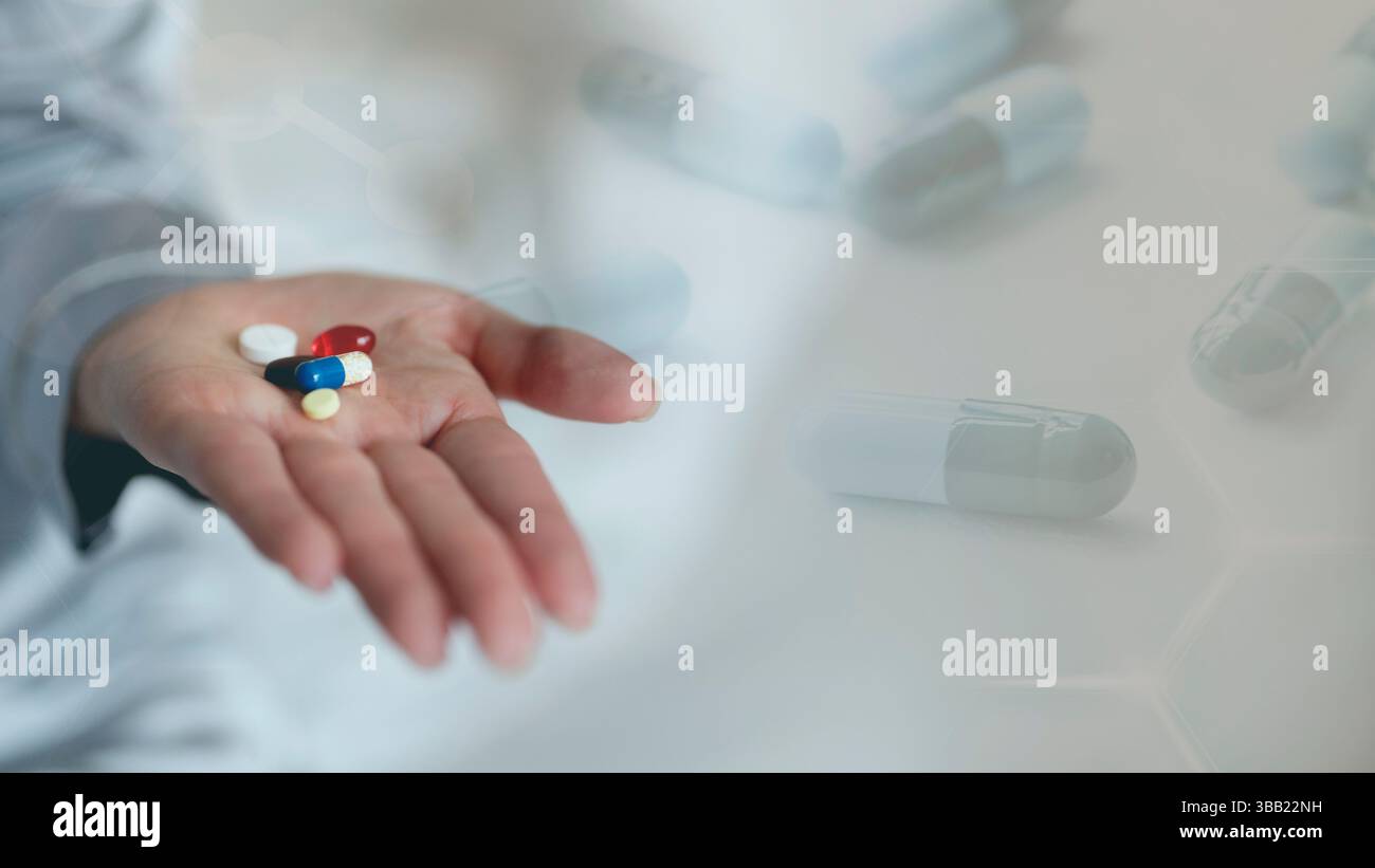 Primo piano che tiene in mano le pillole per i farmaci Foto Stock