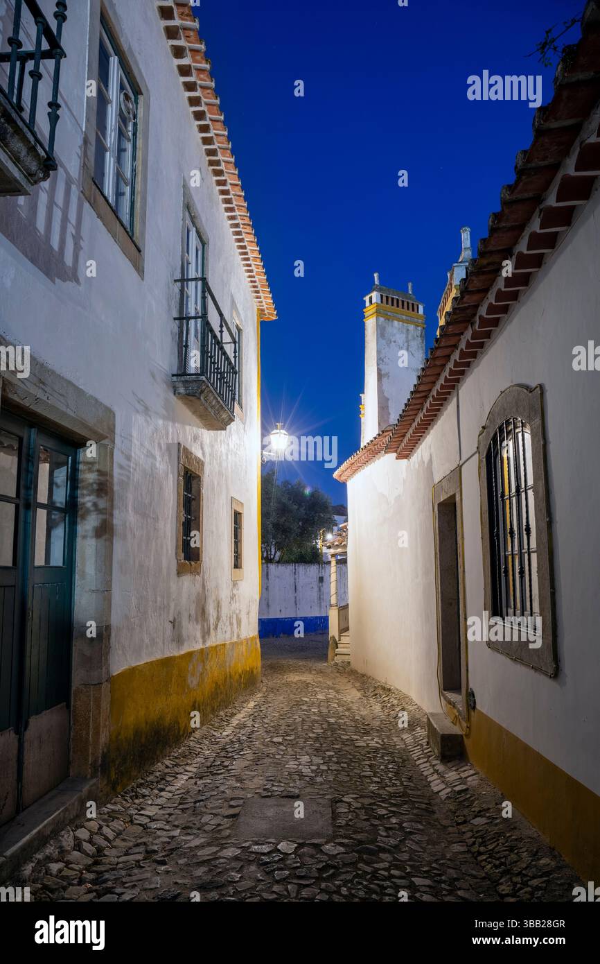 Portogallo, regione di Oeste, Óbidos, Rua Lourenco Marques con architettura tradizionale all'interno della Cittadella murata di notte Foto Stock