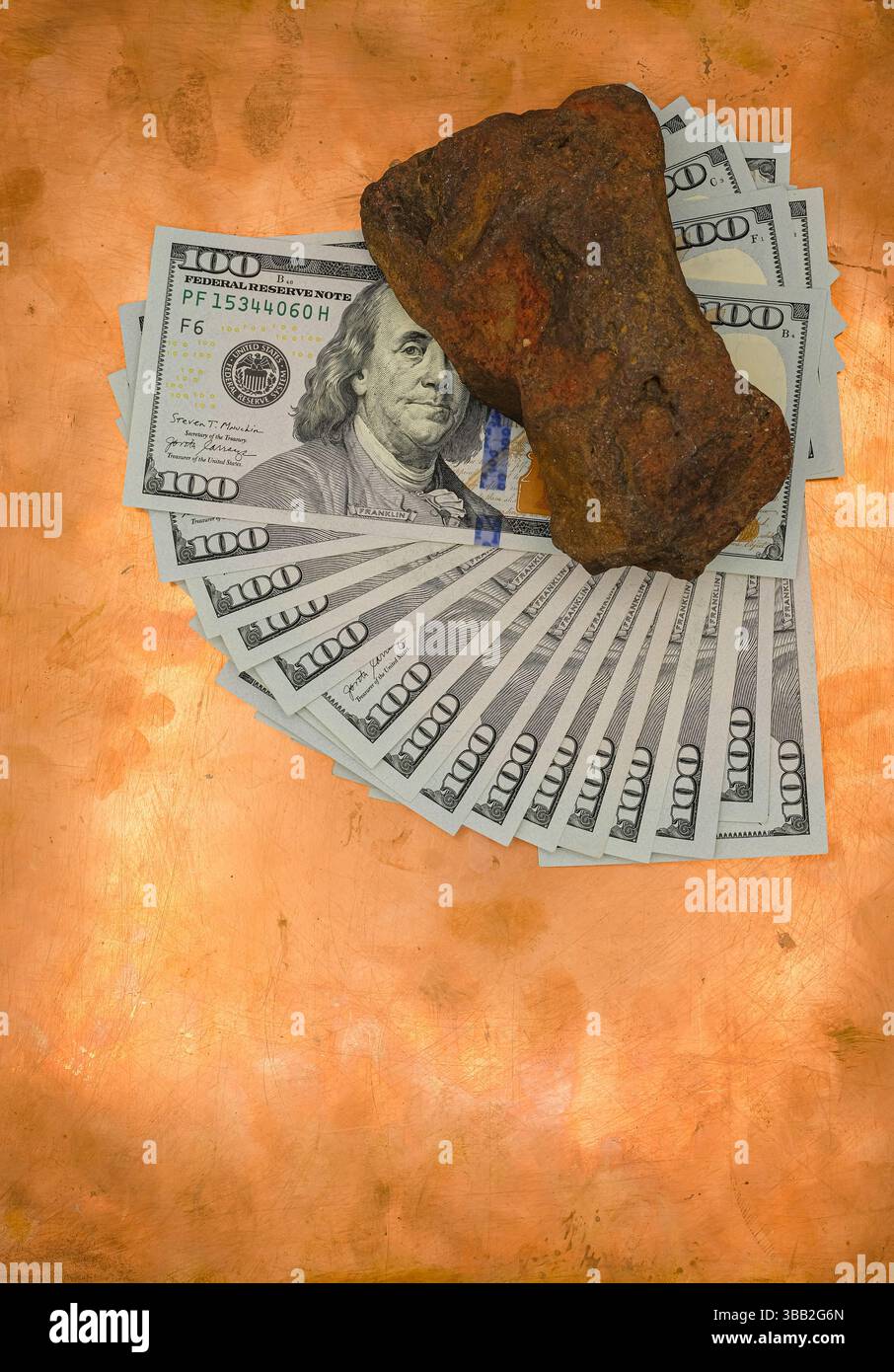 Le banconote da un dollaro sono sparse in un ventilatore su uno sfondo di rame. La pietra ocra rossa giace sulle banconote. Visione metaforica di fare soldi e diventare ricchi. Foto Stock