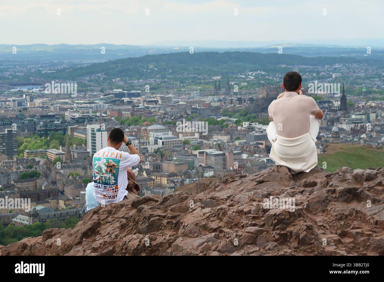Arthur's Seat, Edimburgo, Scozia. I giovani ammirano la vista sulla città dal famoso monumento in un giorno di sole primaverili. Foto Stock