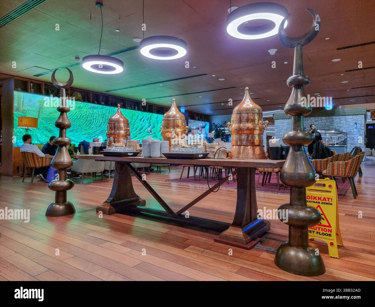 Tavolo da tè turco, bollitori d'acqua in rame e decorazioni con mezze lune nella lounge aeroportuale IST - Immagine stock catturata con smartphone Tavolo da tè turco, bollitori d'acqua in rame e decorazioni con mezze lune nella lounge aeroportuale IST - Immagine stock catturata con smartphone