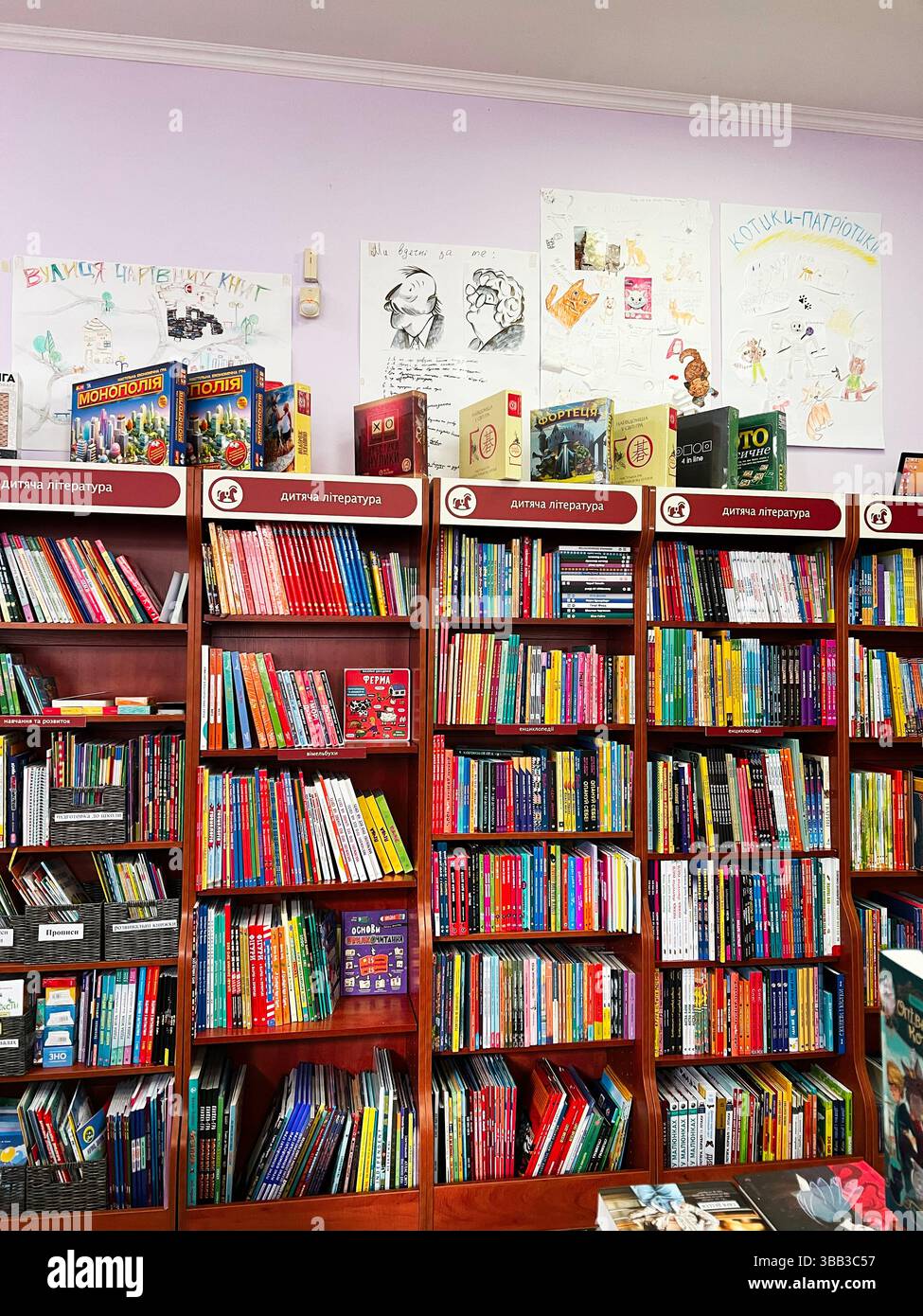 Kiev, Ucraina - 14 maggio 2025: Libri per bambini esposti su scaffali di legno in un accogliente e organizzato librar Foto Stock