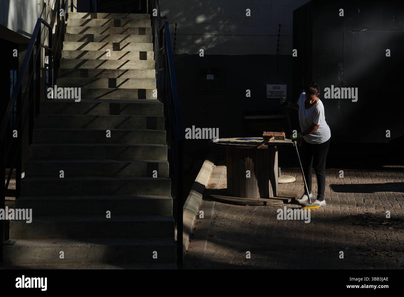 Lavoratrice a città del Capo, in Sud Africa, Una donna spazza accanto a una scala a città del Capo, in Sud Africa, il 14 maggio 2025. Città del Capo Sudafrica Copyright: XMatrixxImagesx/xNicxBothmax Foto Stock