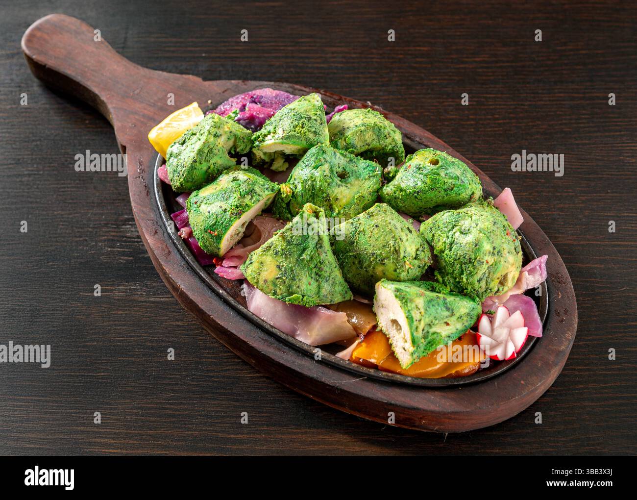 Pudina Tikka, un tradizionale piatto indiano a pezzi di pollo marinato con yogurt, menta e spezie, servito con cipolle su un piatto sfrigolante, isolato su Foto Stock