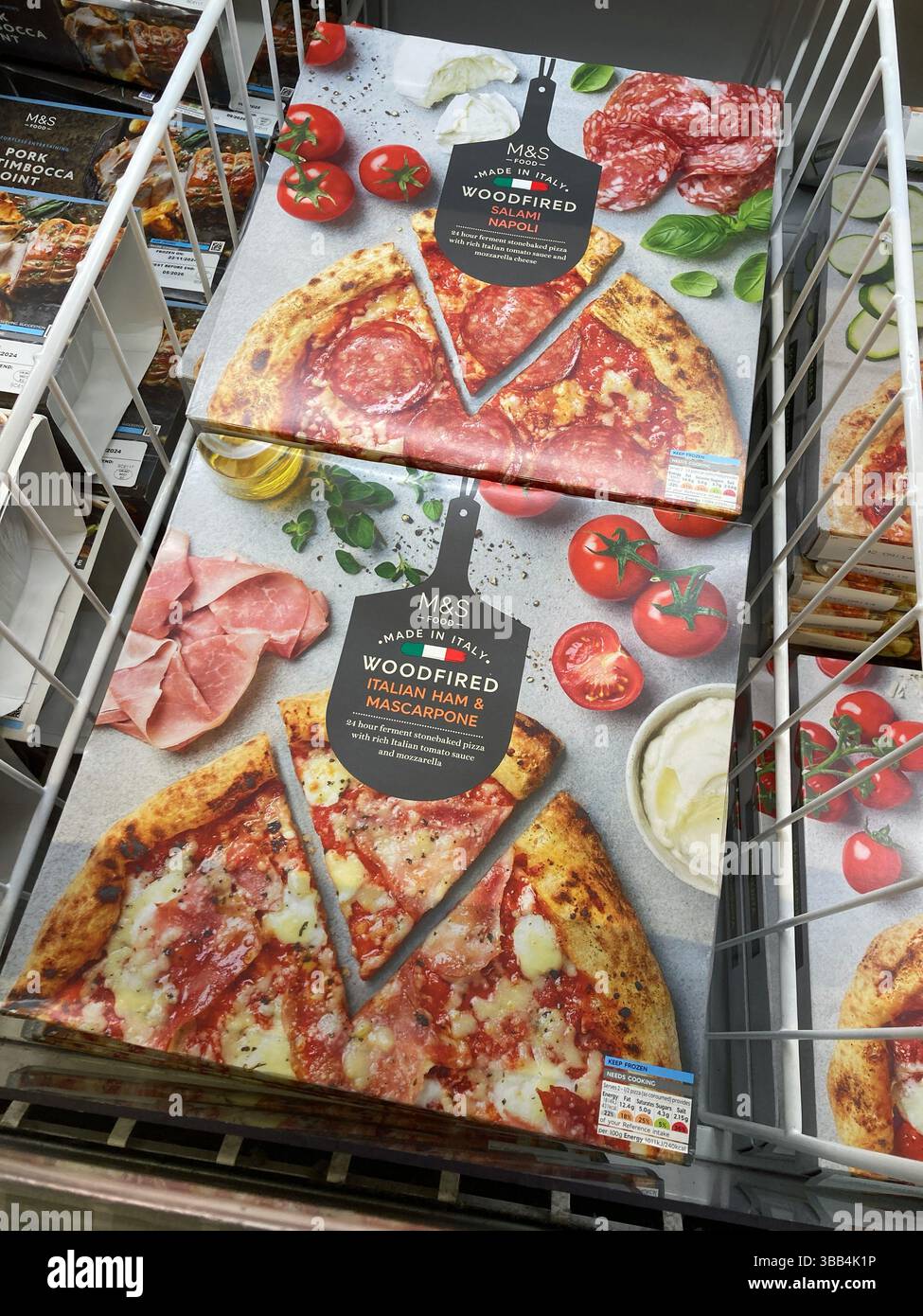 Marchi e confezioni di pizza surgelata cotta a legna di marca Spencer: Salame Napoli e prosciutto italiano e Mascarpone in vendita in freezer, Regno Unito - Immagine stock catturata con smartphone
