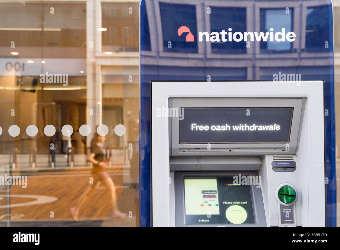 Jogger passa davanti al bancomat sul muro della filiale della società edile di Nationwide , un'importante istituzione finanziaria a Londra nel Regno Unito Foto Stock