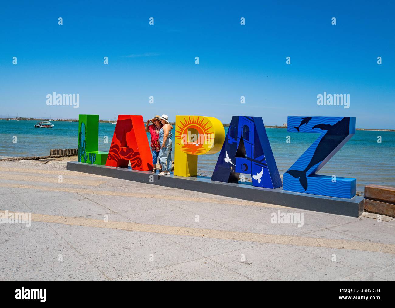 La Paz, BCS, Messico - 23 aprile 2025: I turisti posano sul cartello colorato "LA PAZ" lungo il Malecón a la Paz, B.C.S., Messico Foto Stock