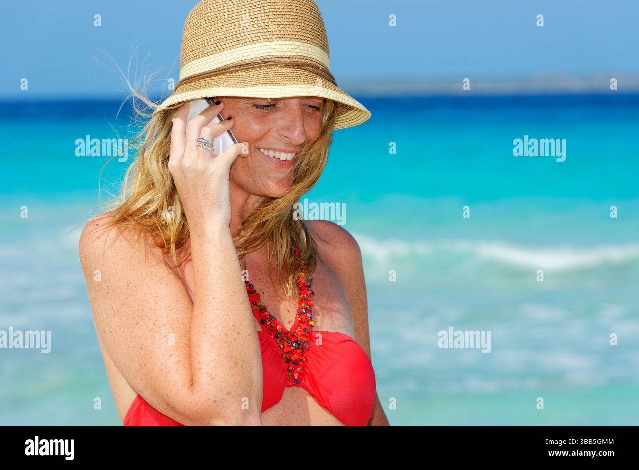 Donna in spiaggia che usa lo smartphone, Formentera, Isole Baleari, Spagna Foto Stock