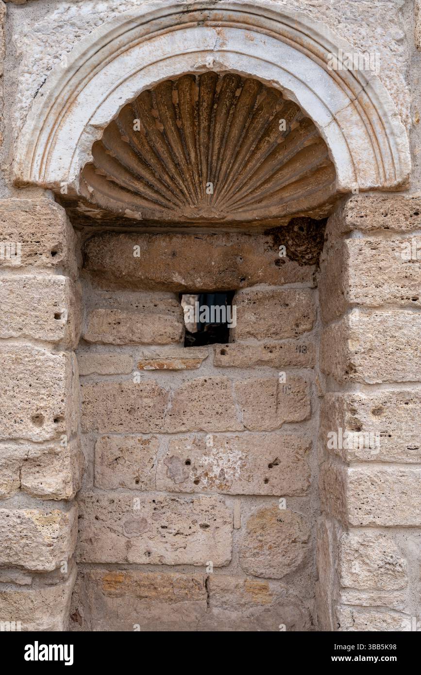 Una piccola nicchia di pietra è scolpita nel muro della Tomba di San Filippo a Hierapolis, circondata da marmo usurato e antichi blocchi. Foto Stock
