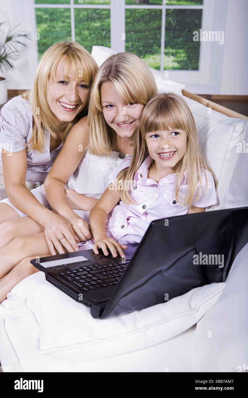 Mamma e figlie che lavorano con un notebook Foto Stock