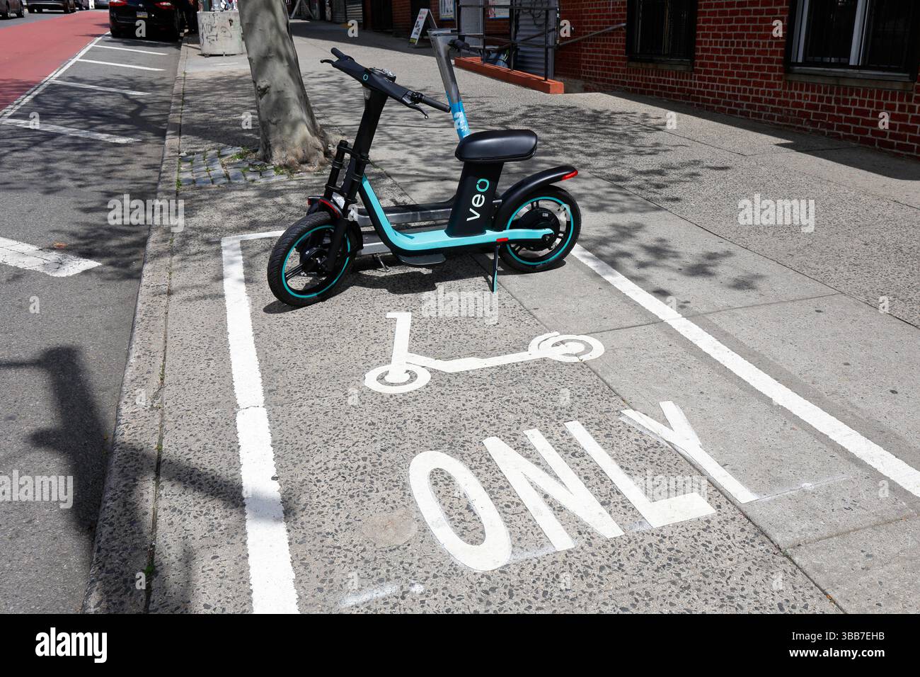 Parcheggio di uno scooter elettrico sul marciapiede corral a Main St e Dahlia Ave a Flushing, Queens, New York City, parte del programma pilota e scooter Share di NYC. Foto Stock