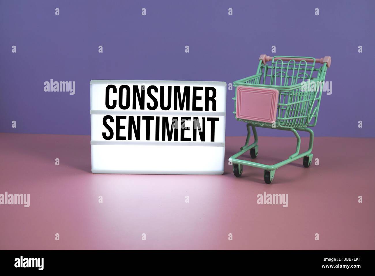 Testo dell'opinione dei consumatori sulla scatola luminosa a LED con carrello della spesa su sfondo geometrico rosa e viola Foto Stock