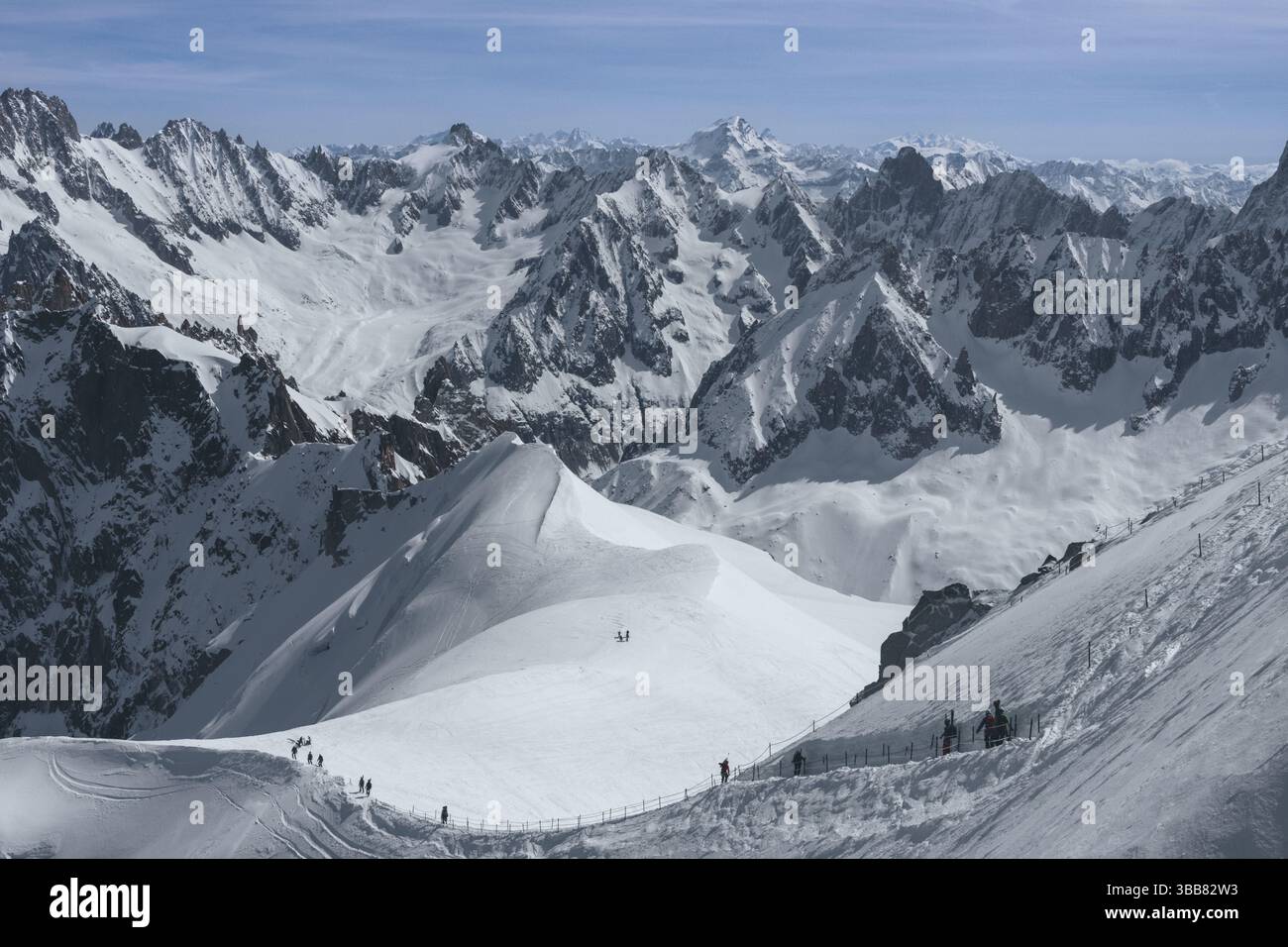 Scialpinisti su una splendida cresta vicino a Aigulle du Midi nel massiccio del Monte bianco nelle alpi francesi sopra Chamonix, con uno scenario montano spettacolare. Foto Stock