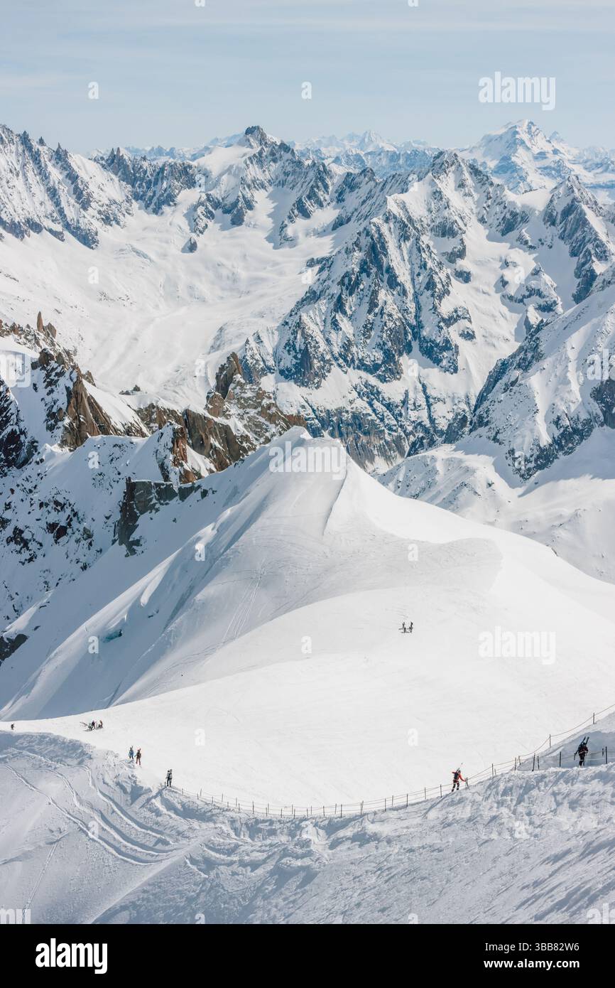 Scialpinisti su una splendida cresta vicino a Aigulle du Midi nel massiccio del Monte bianco nelle alpi francesi sopra Chamonix, con uno scenario montano spettacolare. Foto Stock