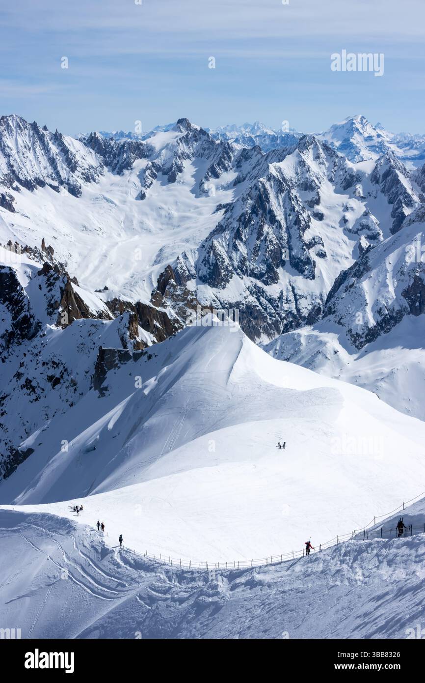 Scialpinisti su una splendida cresta vicino a Aigulle du Midi nel massiccio del Monte bianco nelle alpi francesi sopra Chamonix, con uno scenario montano spettacolare. Foto Stock