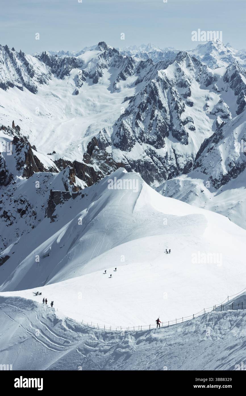 Scialpinisti su una splendida cresta vicino a Aigulle du Midi nel massiccio del Monte bianco nelle alpi francesi sopra Chamonix, con uno scenario montano spettacolare. Foto Stock