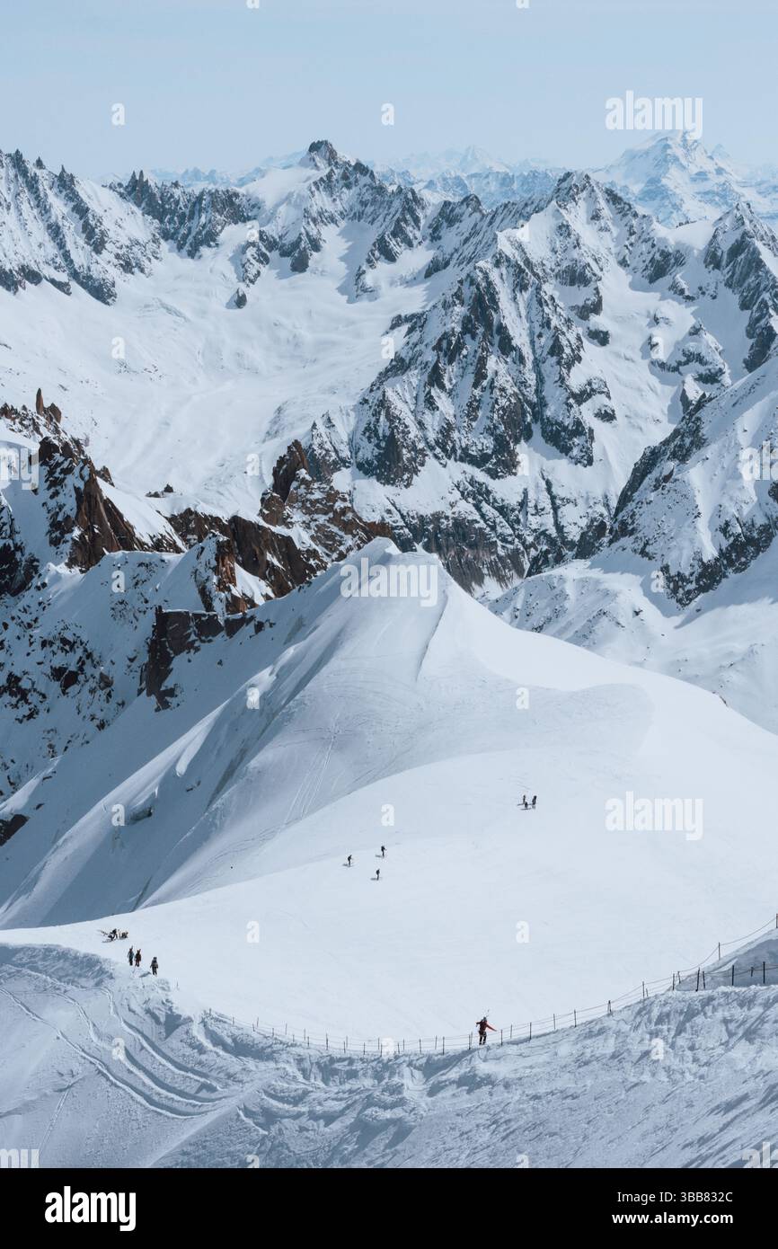 Scialpinisti su una splendida cresta vicino a Aigulle du Midi nel massiccio del Monte bianco nelle alpi francesi sopra Chamonix, con uno scenario montano spettacolare. Foto Stock